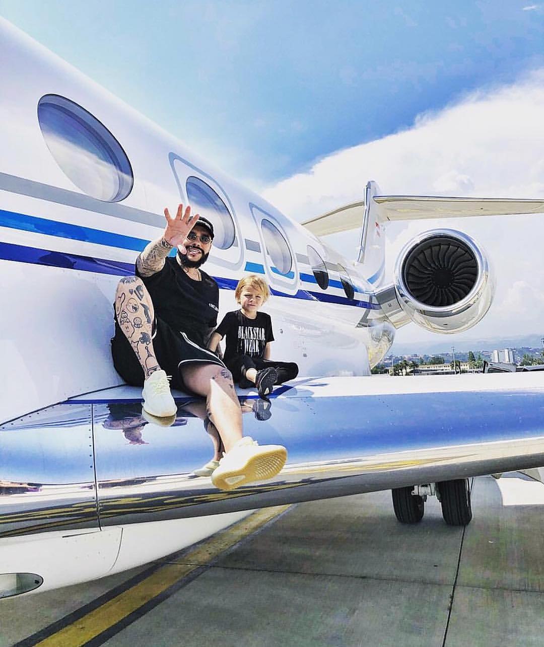 Père et enfant en tournage sur l'aile d'un jet privé
